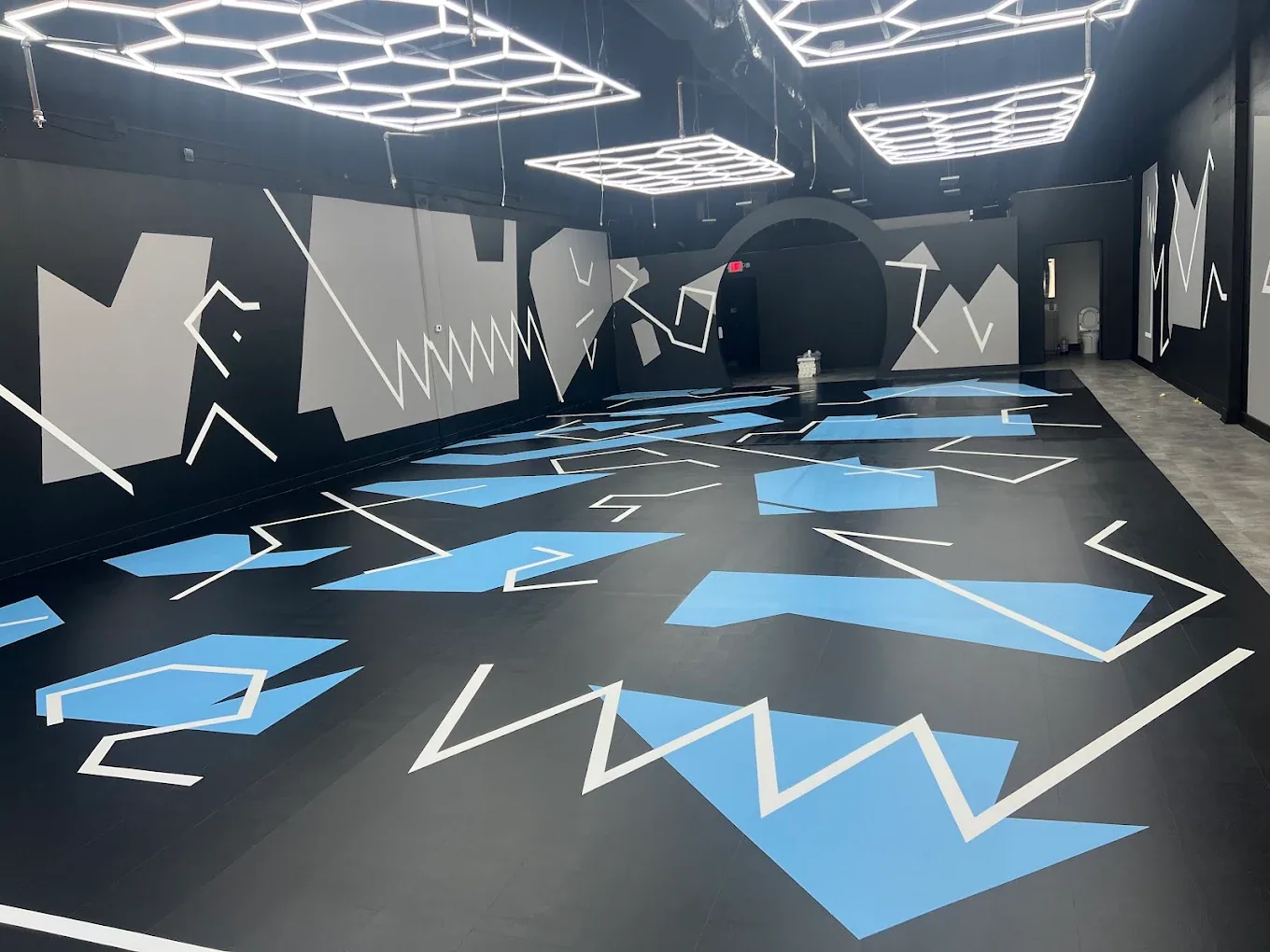 Commercial recreation space with black, white and blue geometric painted surfaces