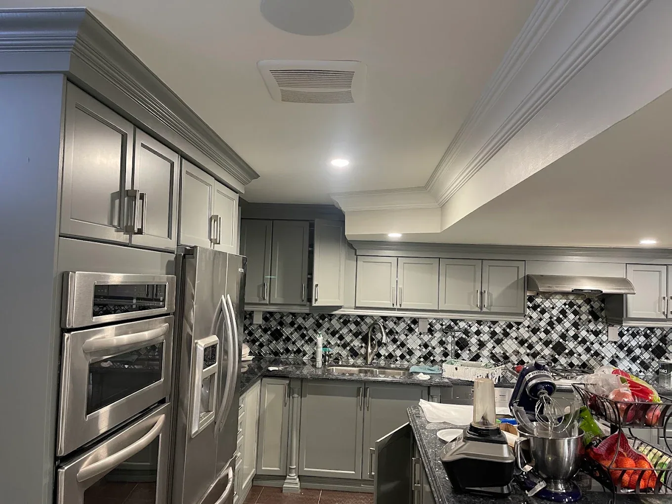 Kitchen with grey cabinetry, white ceiling and detailed crown moulding