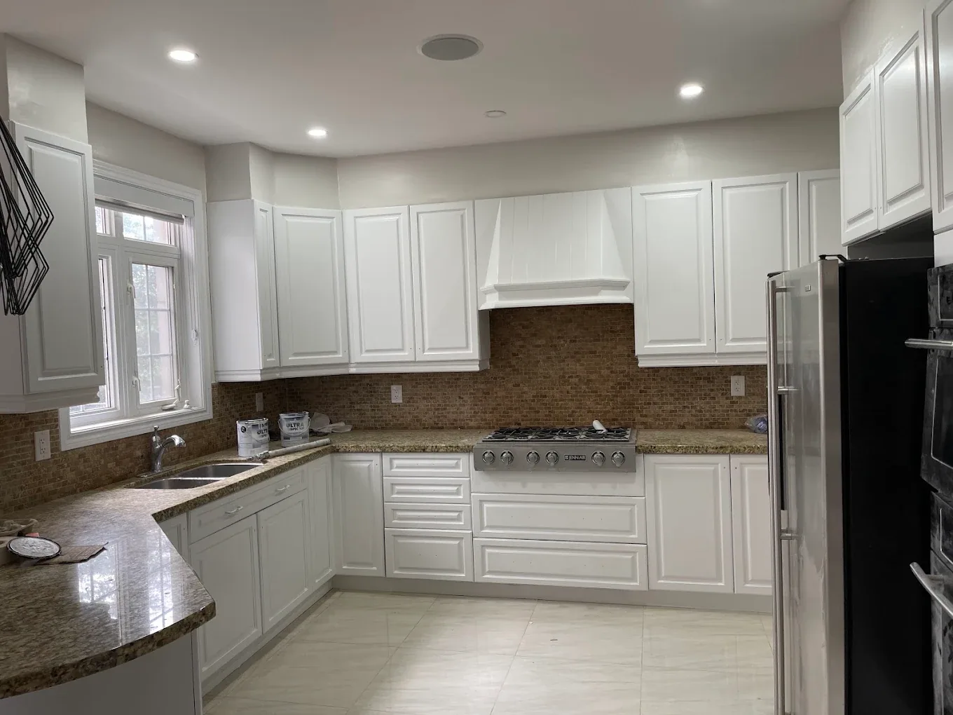 Bright kitchen with white cabinetry, ceiling and trim